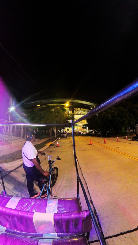 Pedicab waiting near a Houston stadium during a night ride